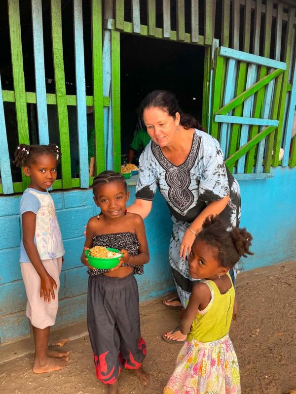 A member of the team serving rice to young children at the Tuesday feeding programme in Mahajanga